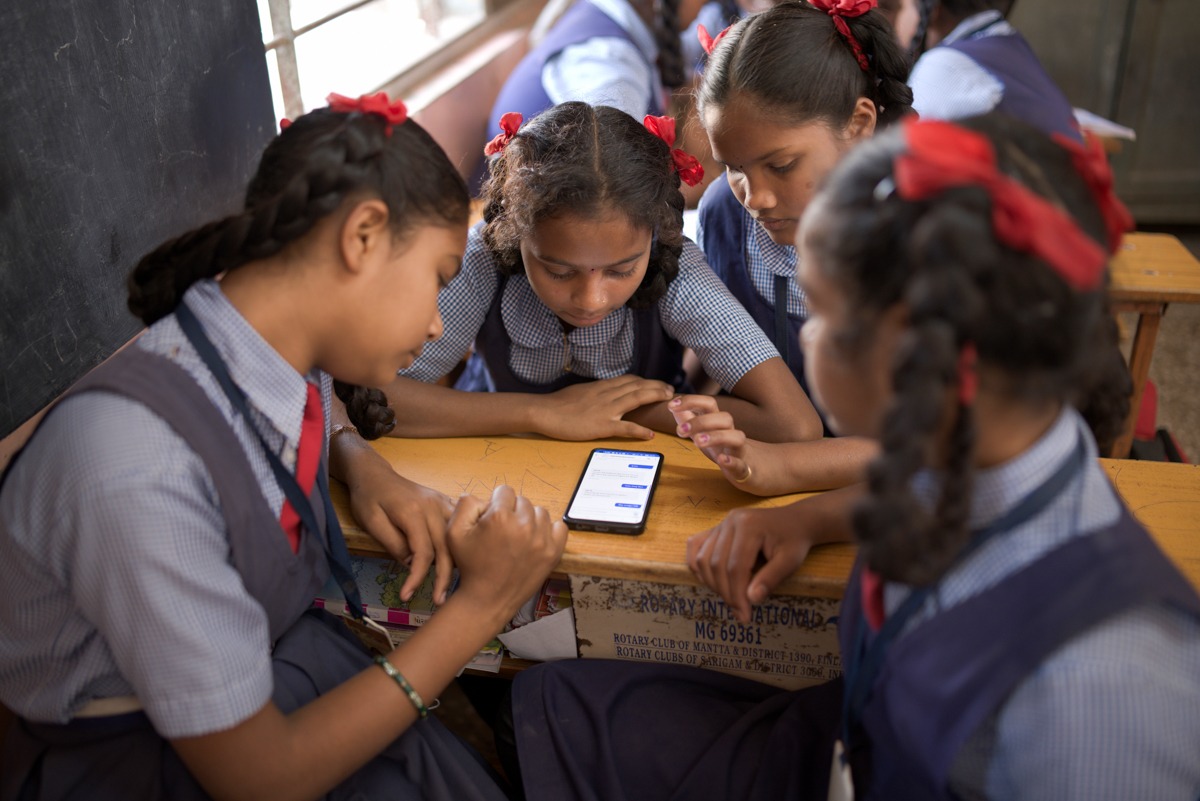 Students gathered around a smart phone