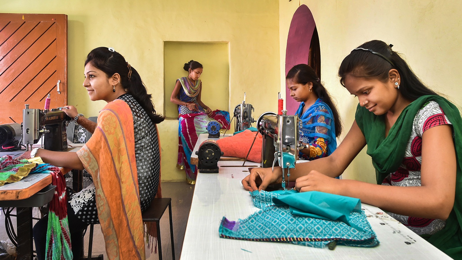 Four women work on sewing projects in India.