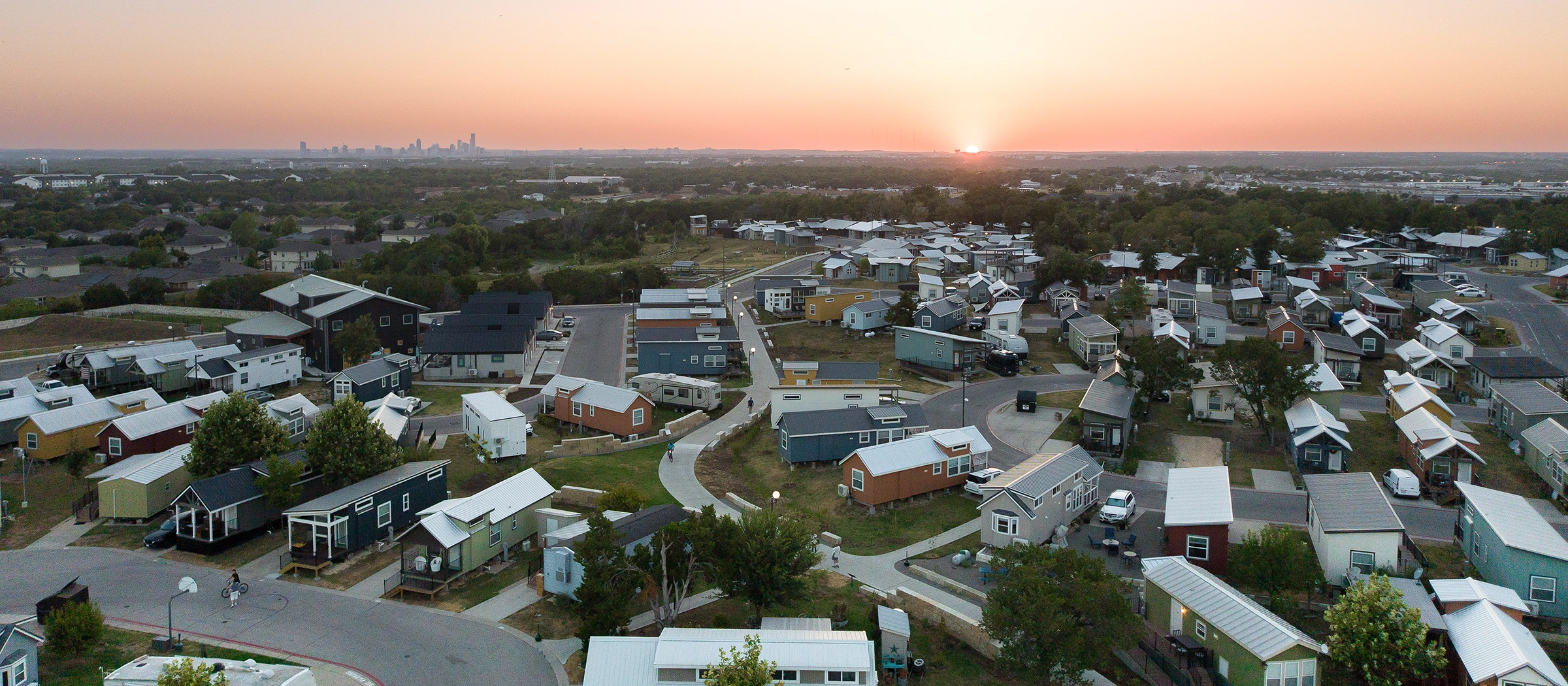 Aerial shot of Community First! Village against the backdrop of the Austin Skyline at sunrise.