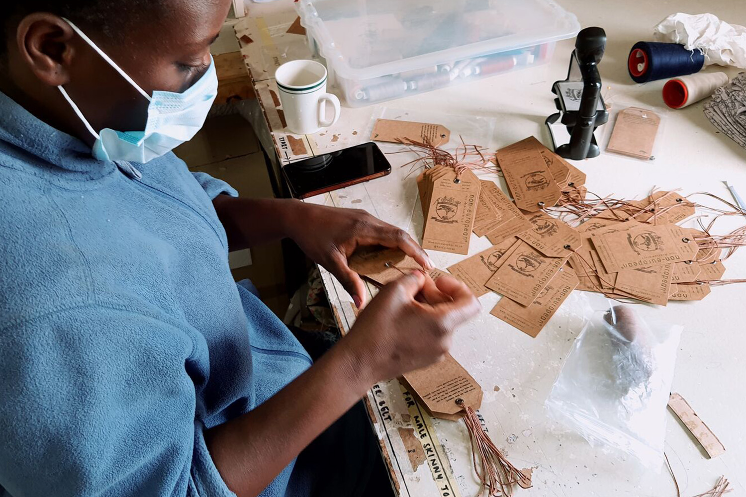 A worker prepares tags for clothing.