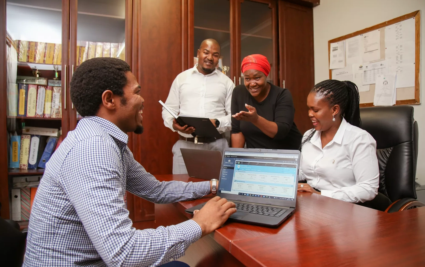 A group of South African educators review data in an office.