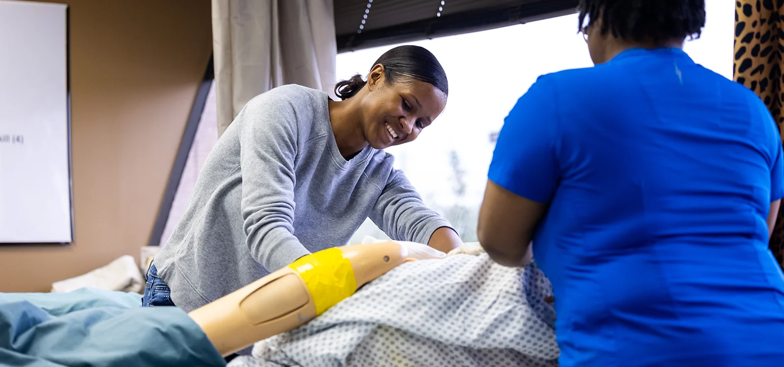 Two women participate in a Nurse Assistance Training program.