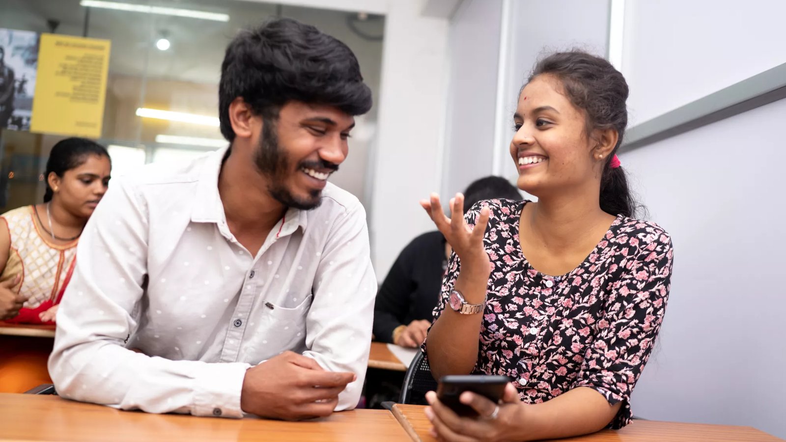 A group of Indian students chat in a school lobby.