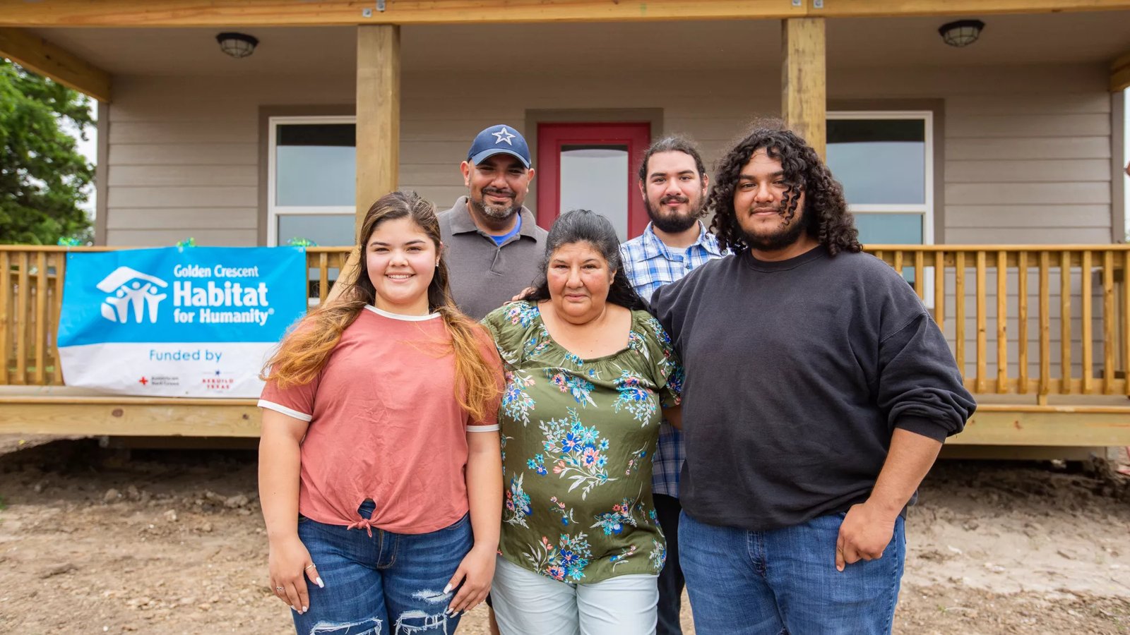 A family stands in front of their newly built home.