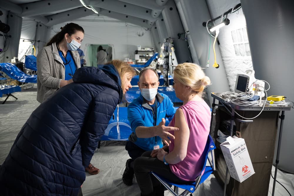 A medical worker checks on a patient.