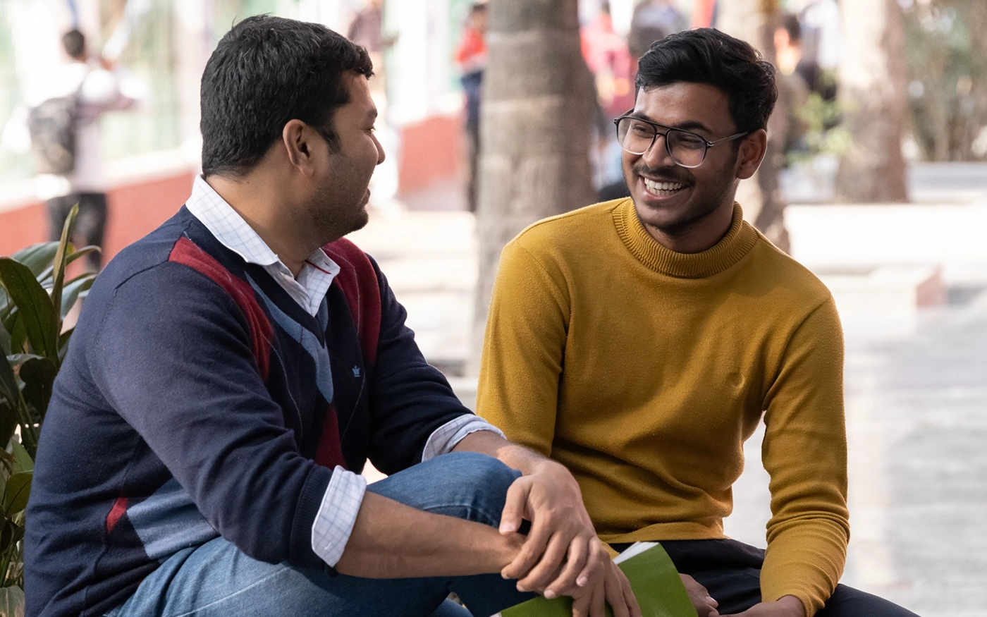 Student and mentor talking on a college campus.