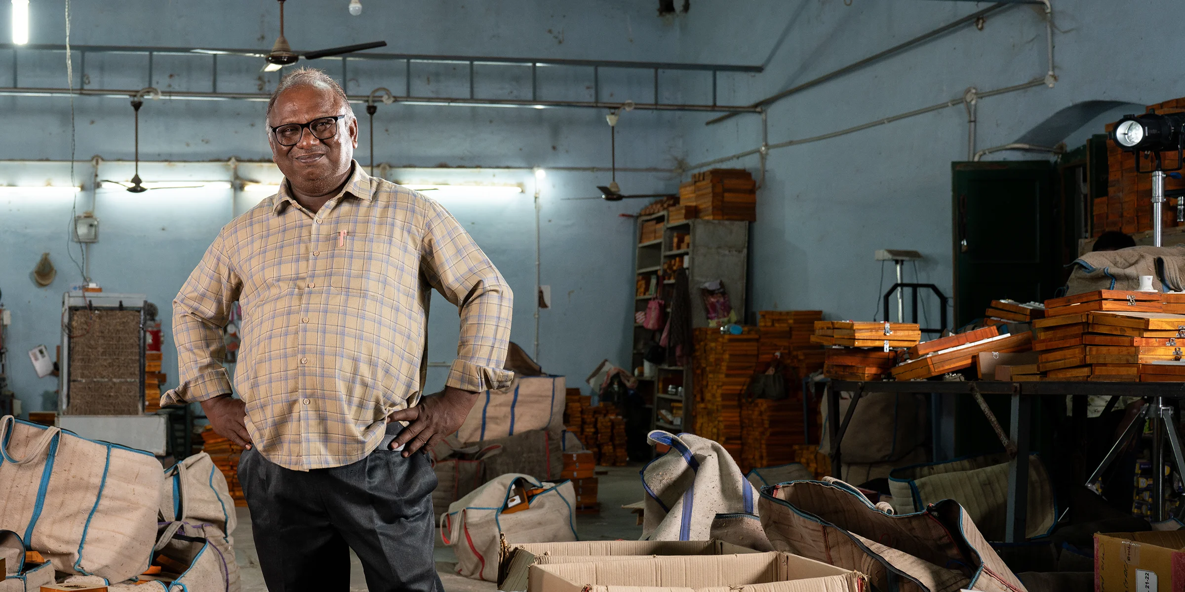 A man stands among inventory in a shop.