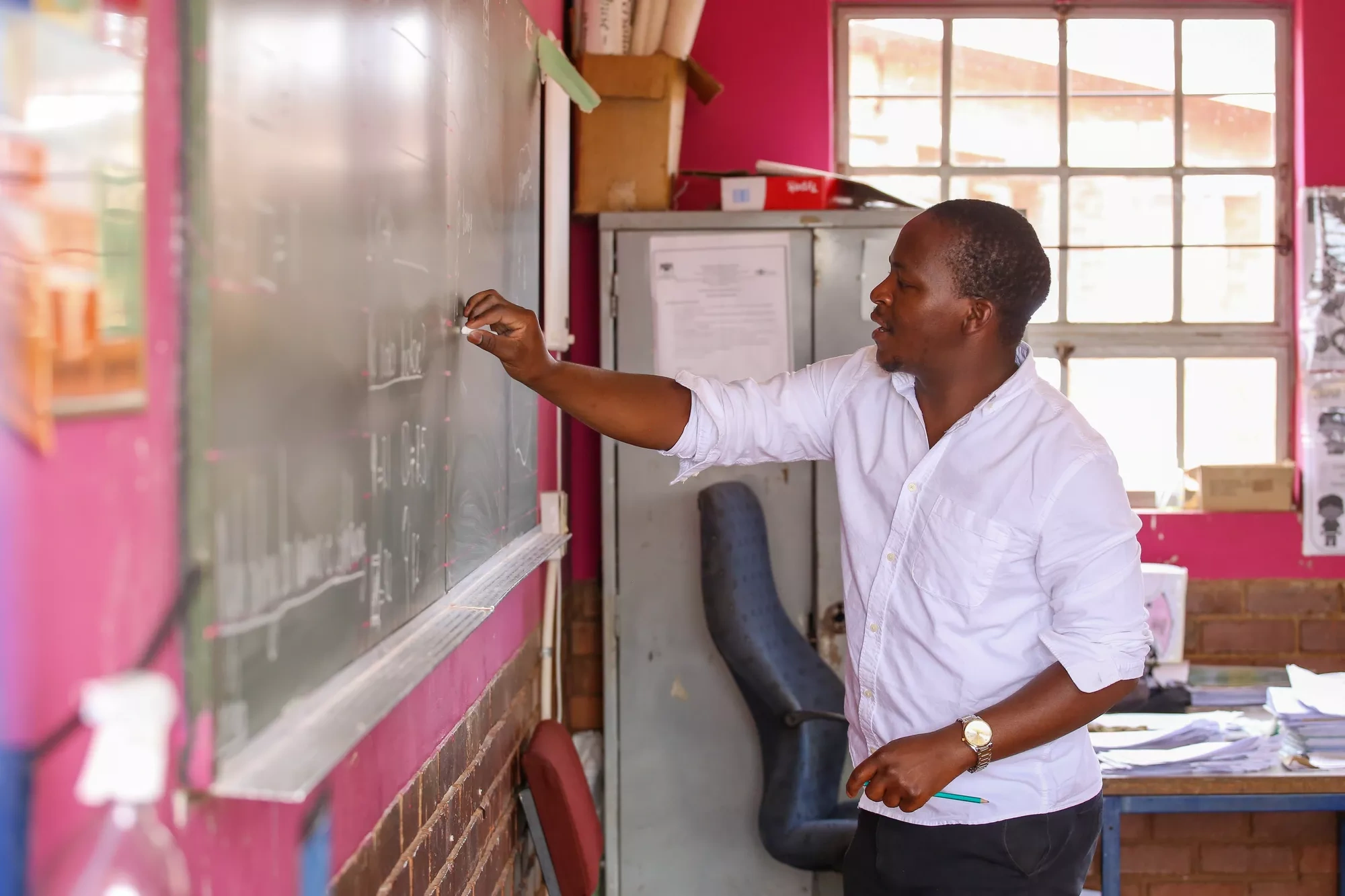 A teacher writes on a chalkboard at Sedibeng Primary School in Thembisa, Johannesburg, South Africa.