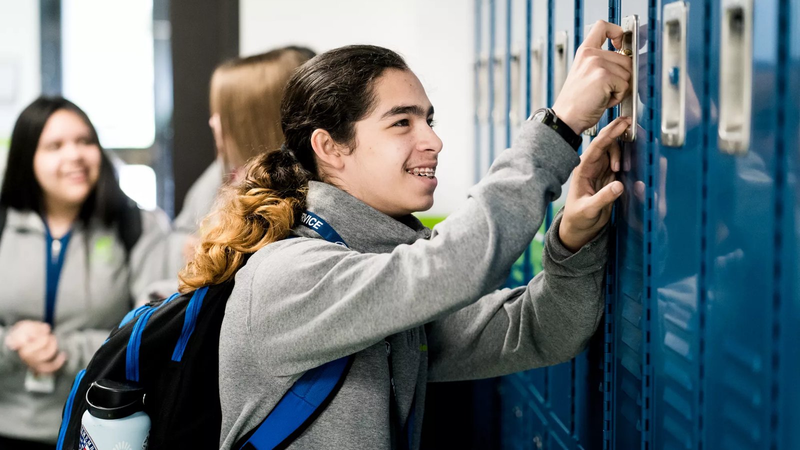 A student unlocks his locker.