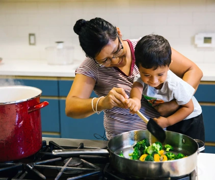 A woman and child cook vegetables together.