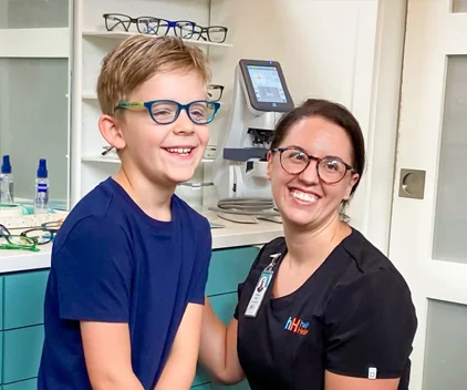 A boy tries on his glasses at the doctor's office.