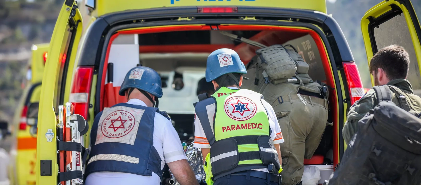 Paramedics load a patient into their ambulance.