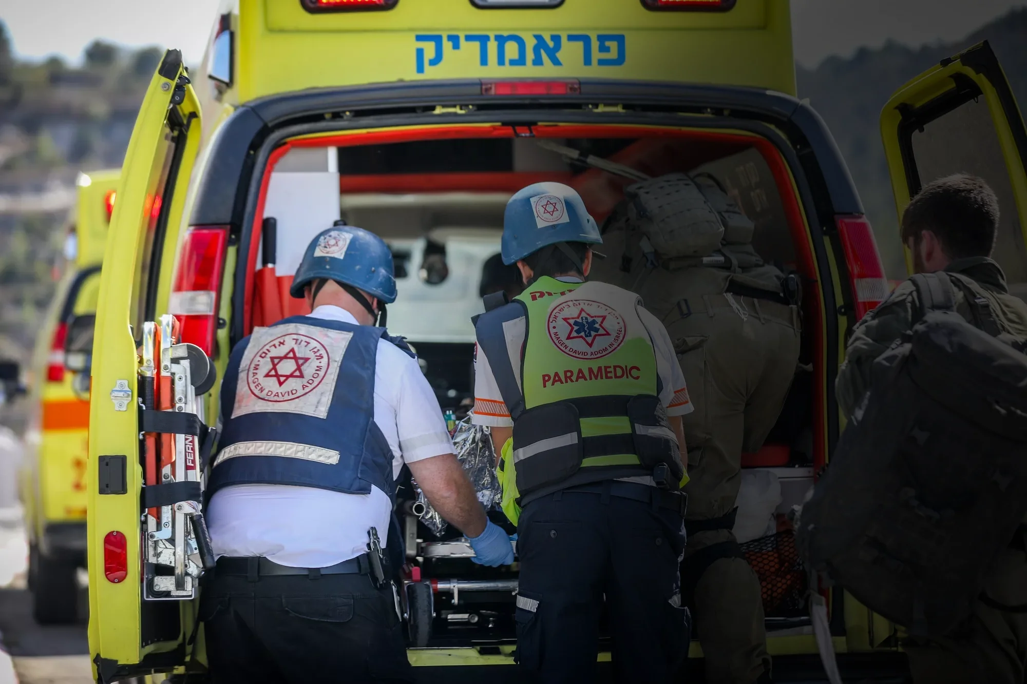 Paramedics load a patient into an ambulance.