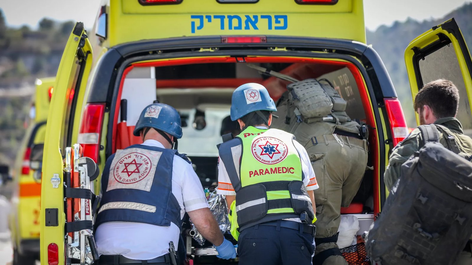 Paramedics load a patient into an ambulance.