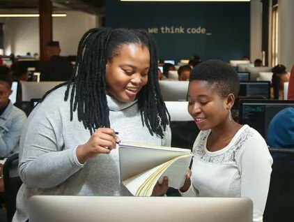 Two young South African women work in an office.