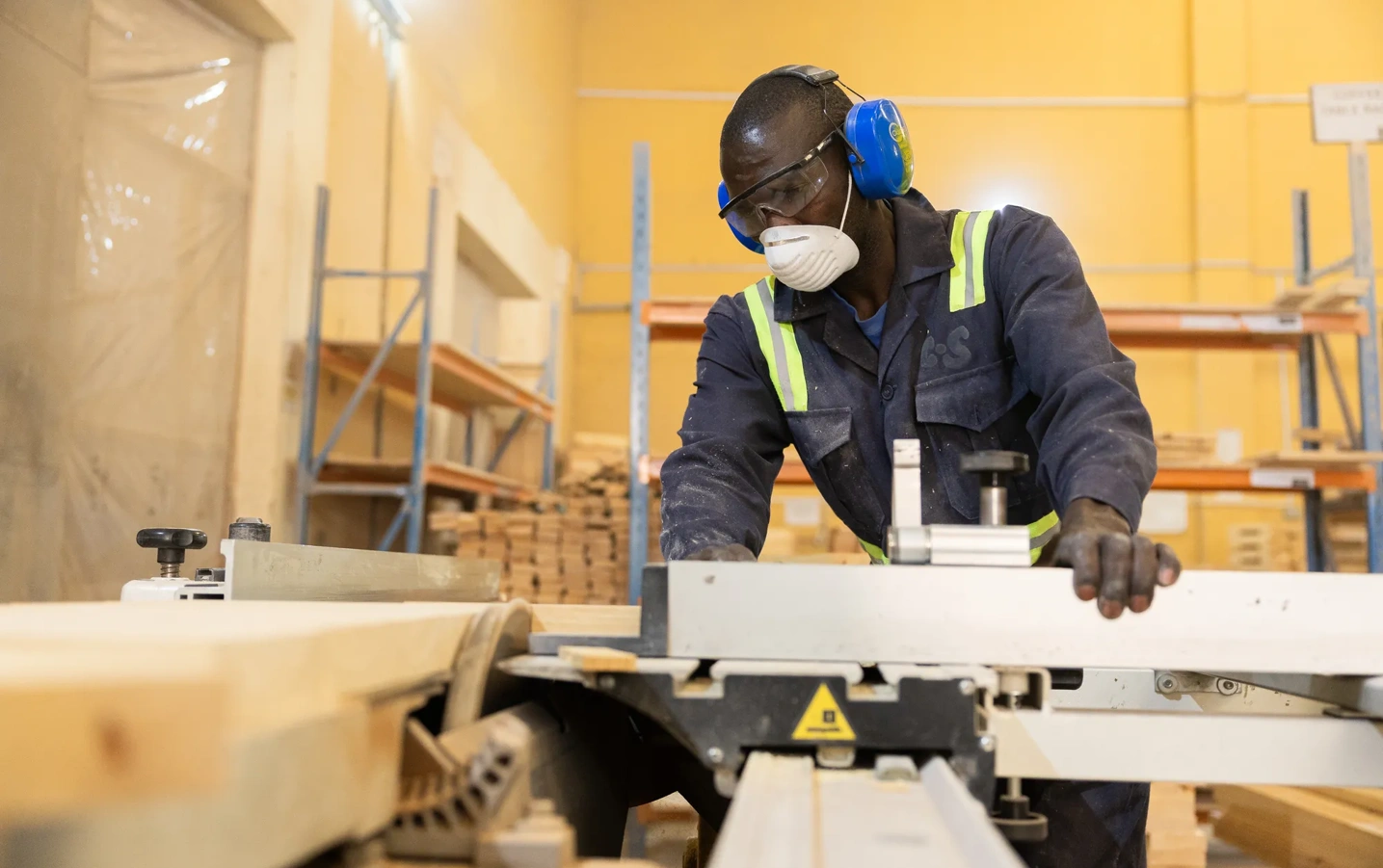 A man works heavy machinery in a factory.