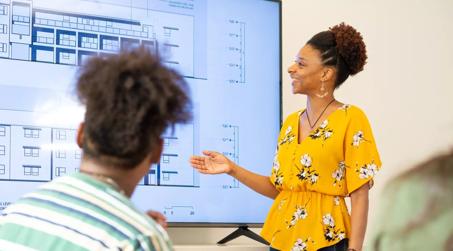 A woman gives a presentation at an office.