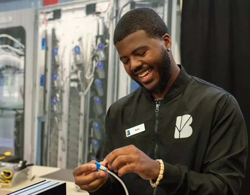 A young man works on a networking project at a career fair.