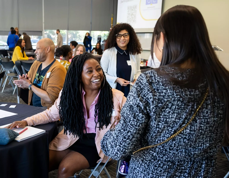 Two women chat at a round table.