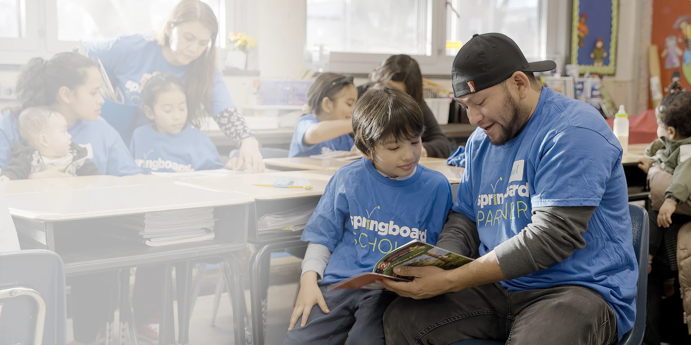 A Springboard Collaborative partner reads to a child in a classroom.