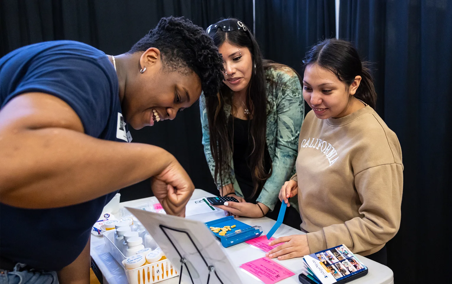 A facilitator and two students at a Career Fair.