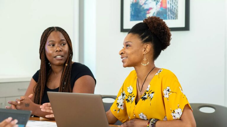 A Lifeworks client sits at a table with a staff member.