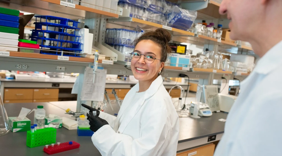 A doctor smiles while working in a lab.